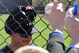 Alex Rodriguez, with glove on head, signs for fans following a practice in Tampa