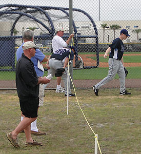 A Rays fan holds up a rope for a Rays pitcher during a practice in Port Charlotte